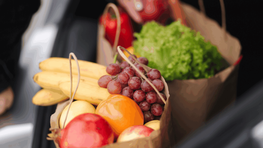 Verdure colorate, spezie come curcuma, zenzero e cannella, e frutta antiossidante come mirtilli e melograno disposte artisticamente su sfondo in legno.